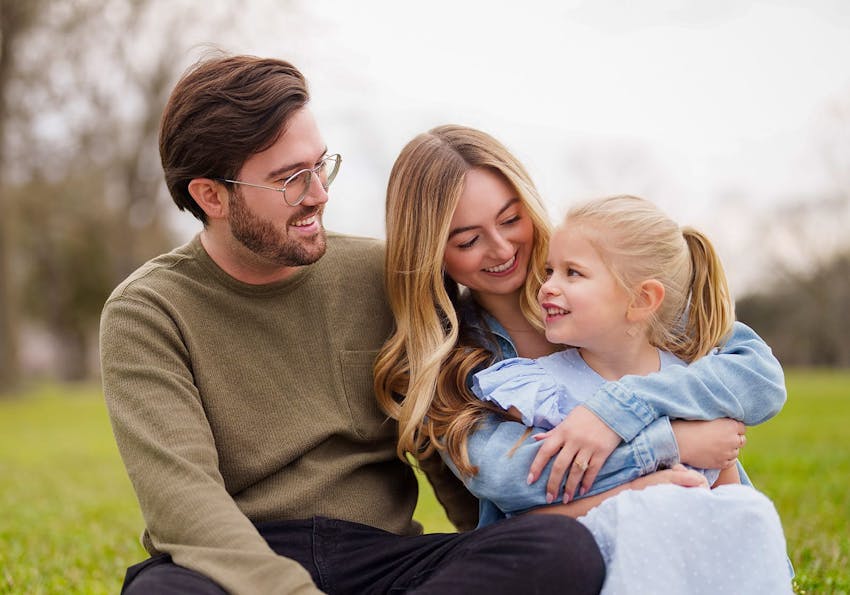 man and woman sitting with a child