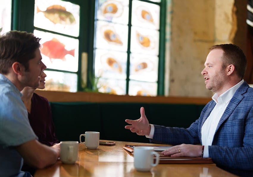 attoeney talking with clients at a table