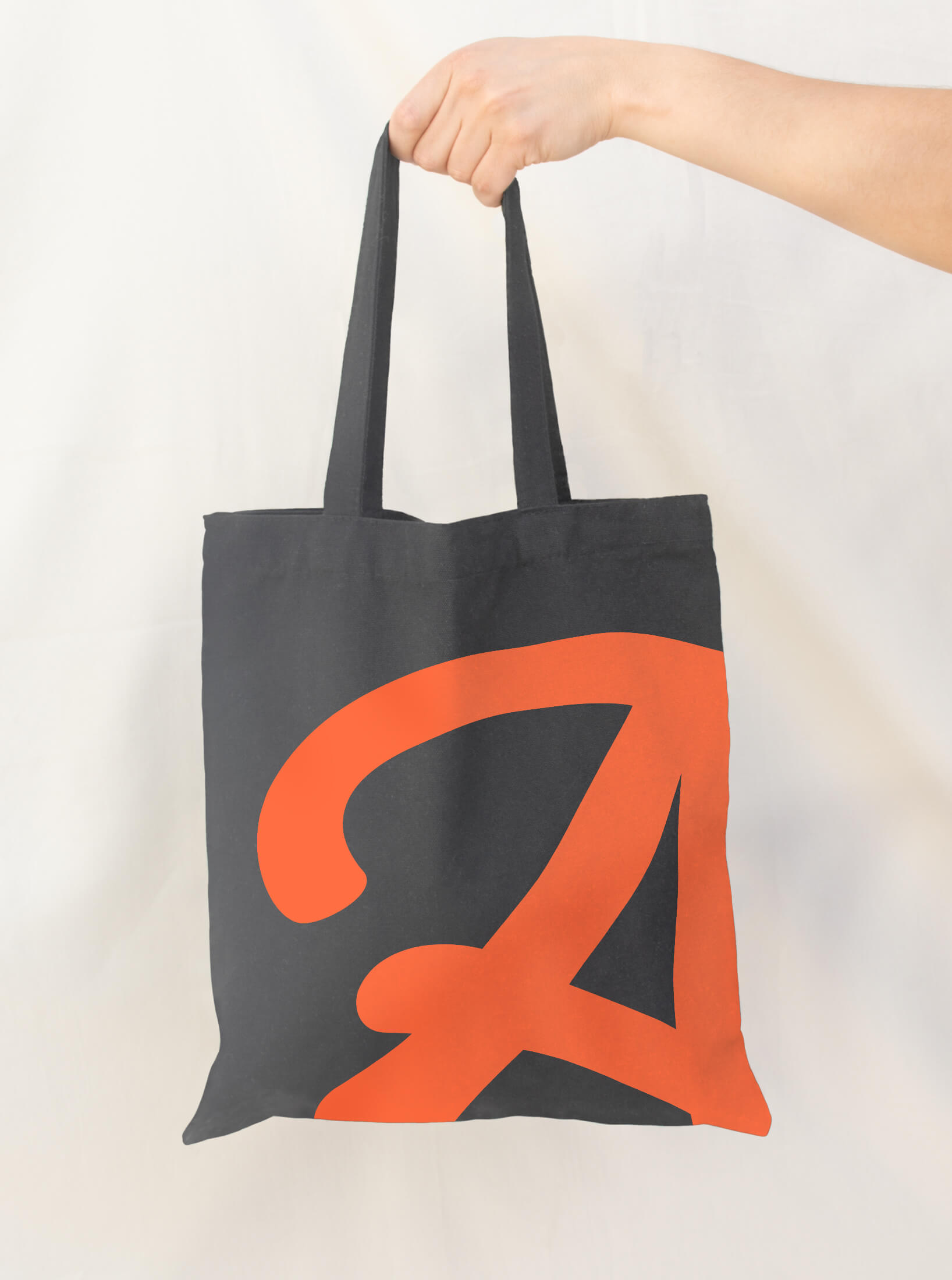 Tote bag featuring the Armadillo brand logo in bold orange lettering.