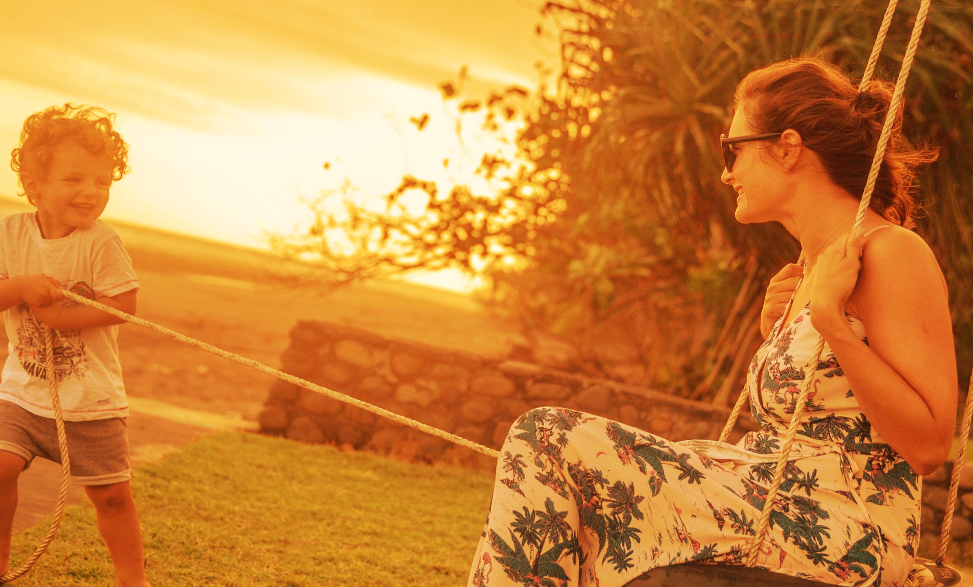Woman enjoying sunset outdoors with warm golden lighting.