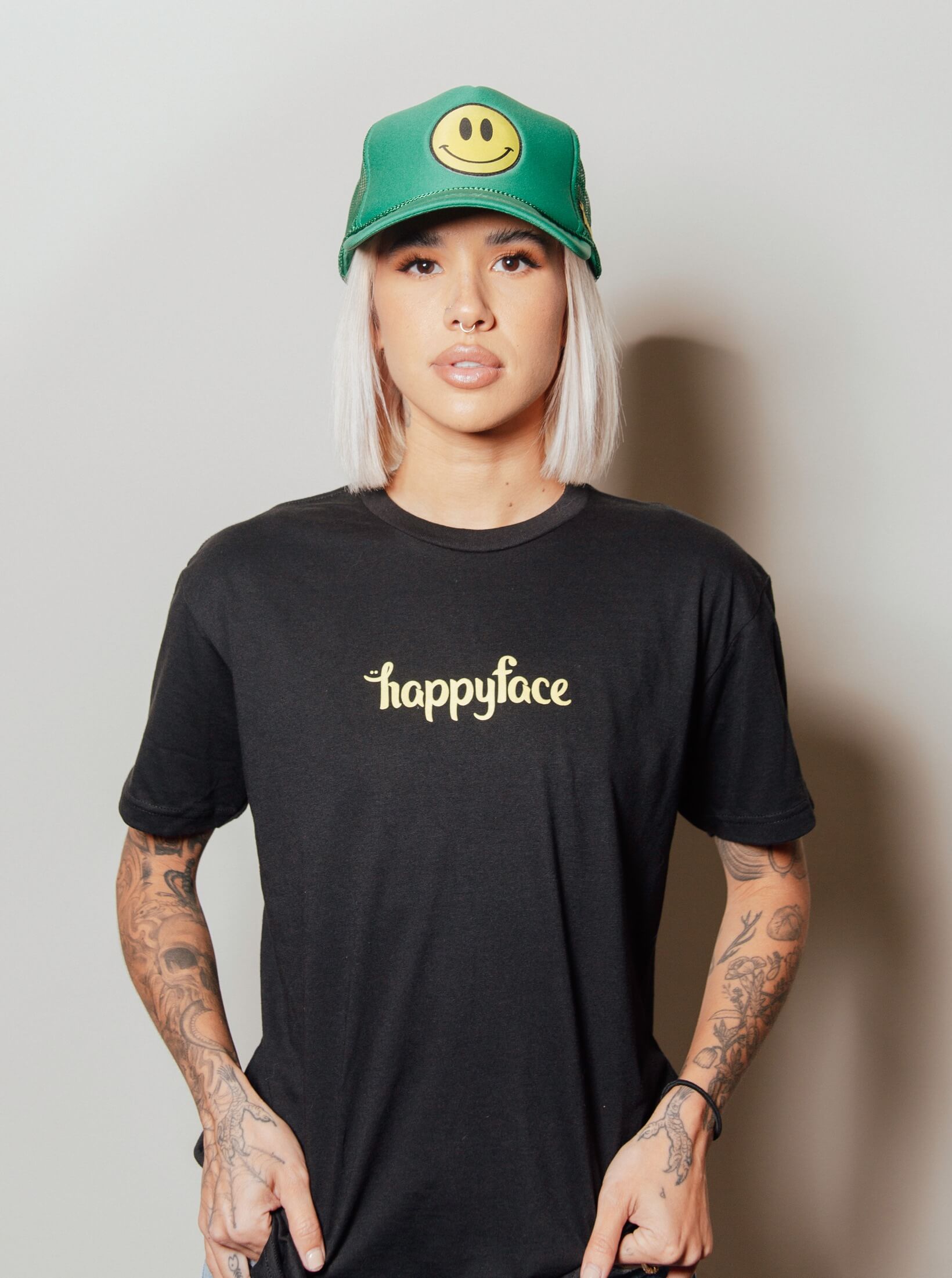 Person wearing black Happy Face T-shirt with smile logo.