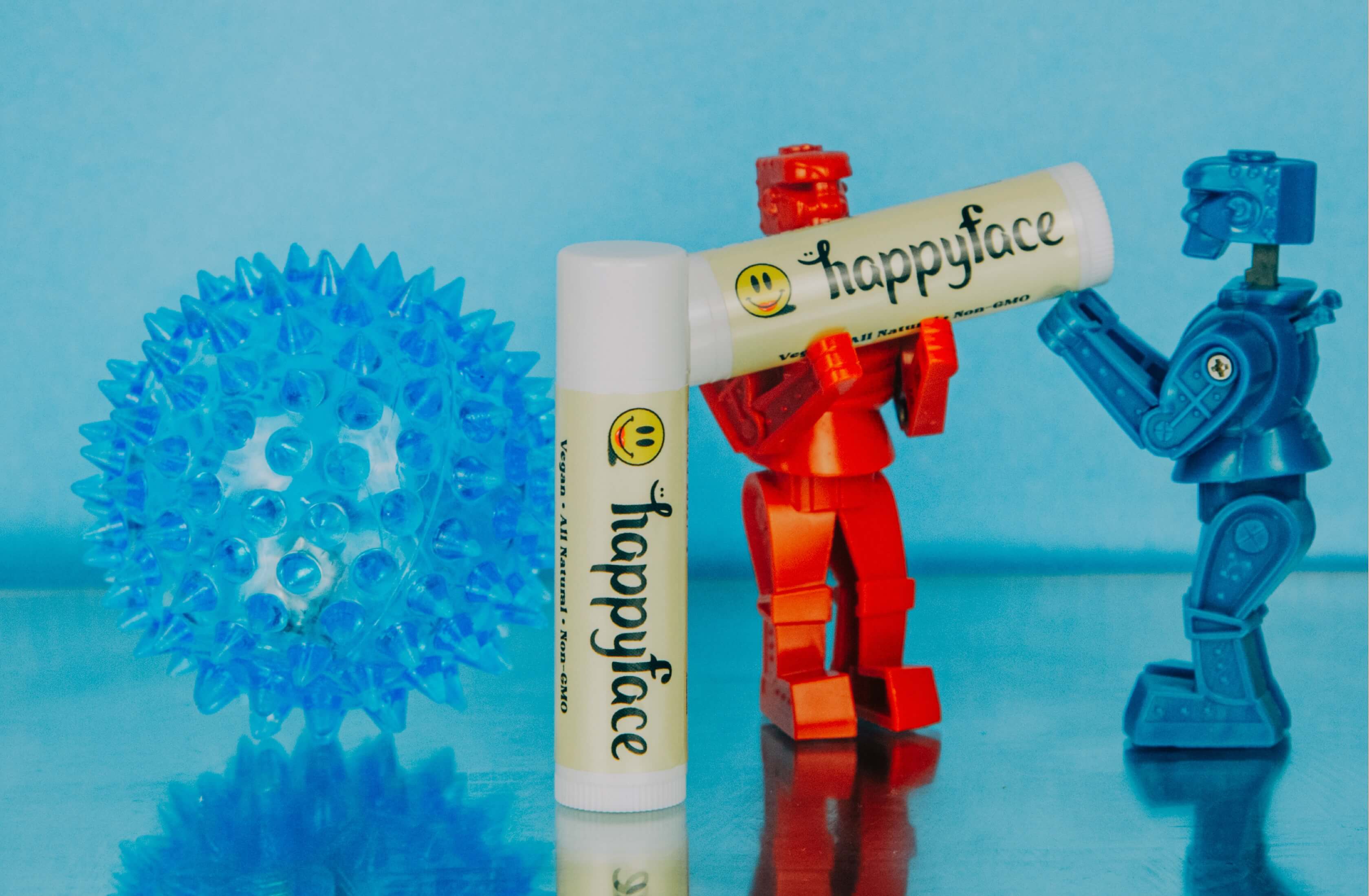 Happy Face product campaign artwork with playful blue and red graphics.