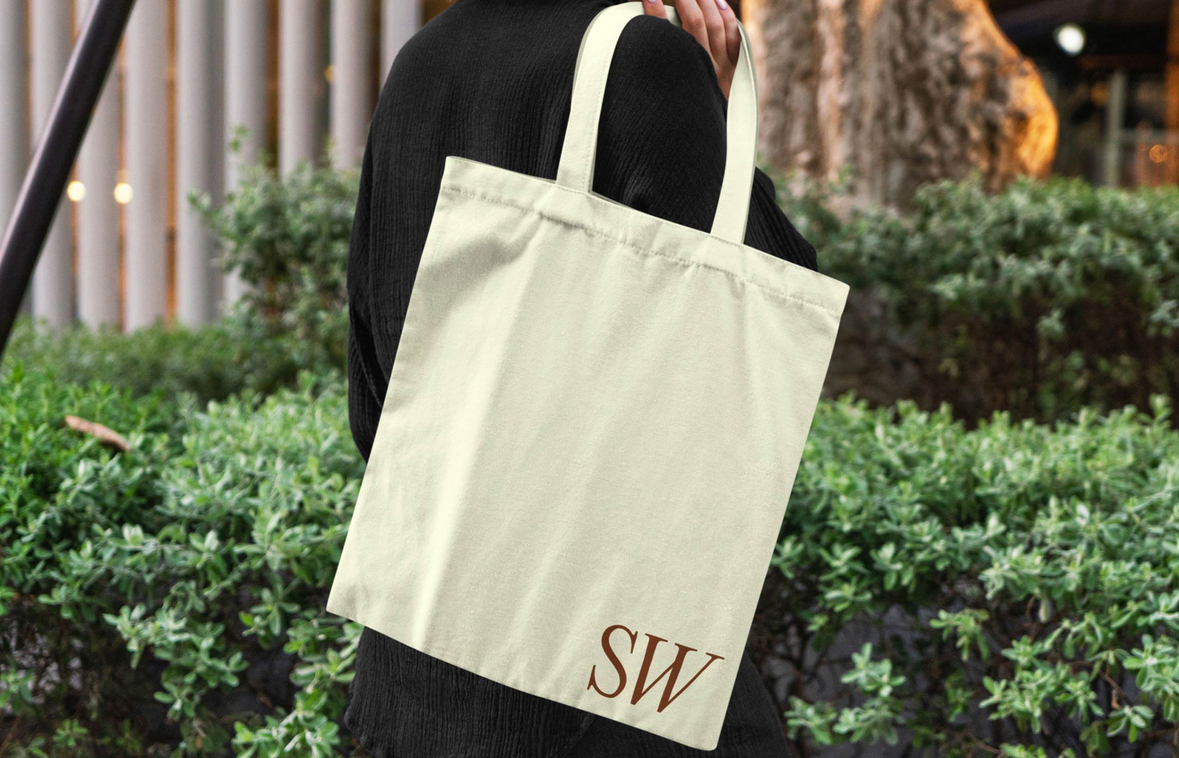 Tote bag printed with Suzy Welch branding photographed outdoors.