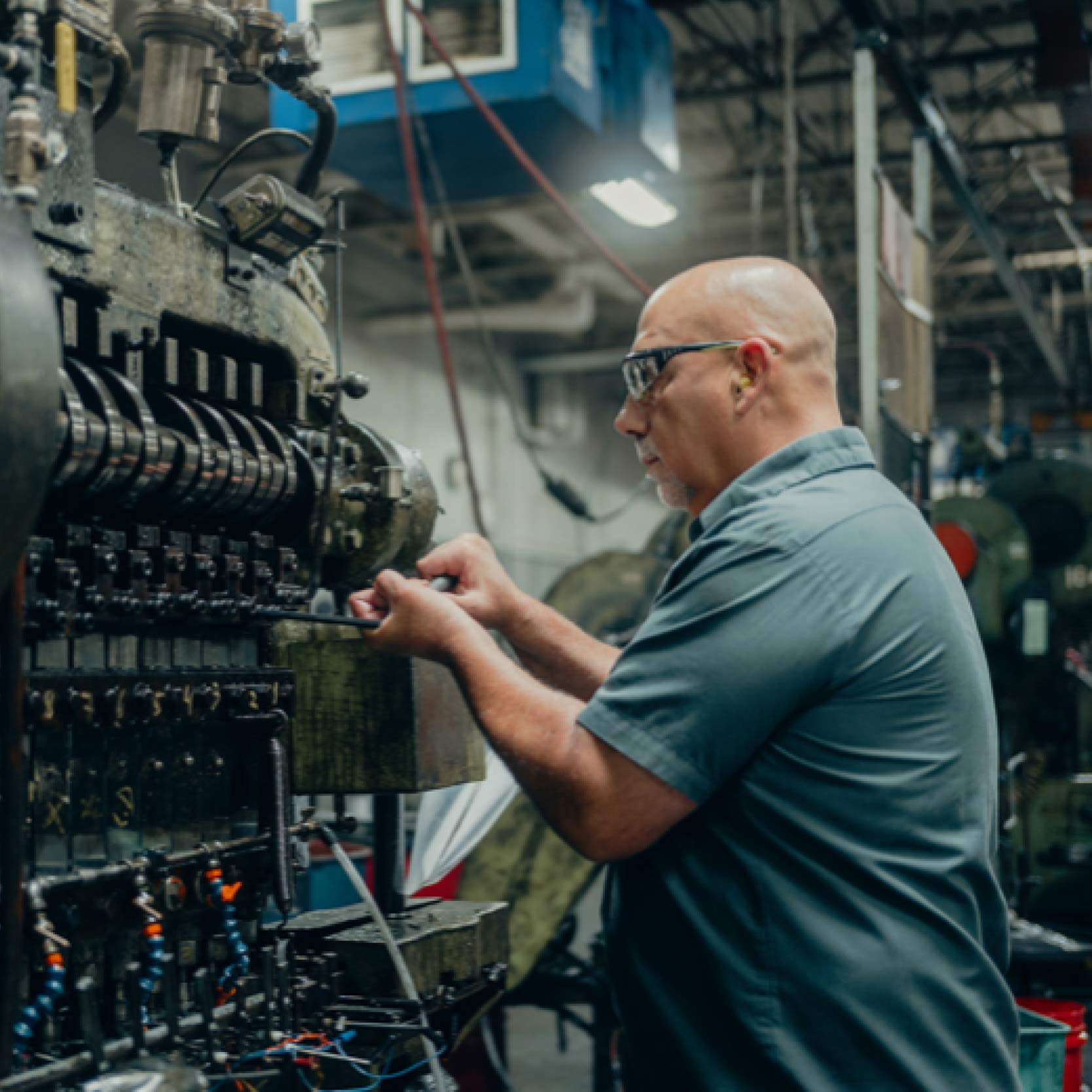 Technician inspecting machinery inside the Cly-Del production floor.