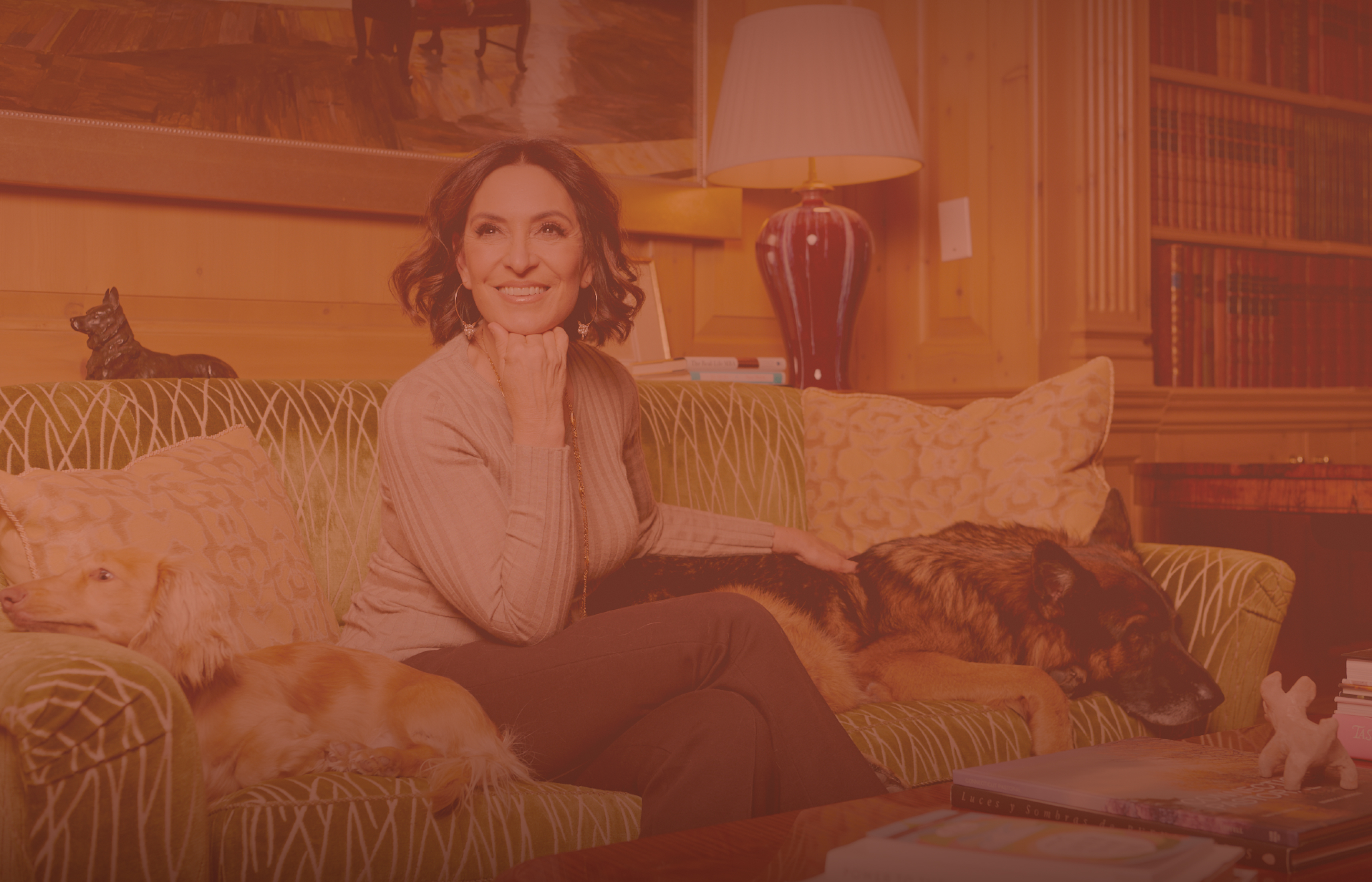 Portrait of Suzy Welch smiling in a warmly lit home environment.