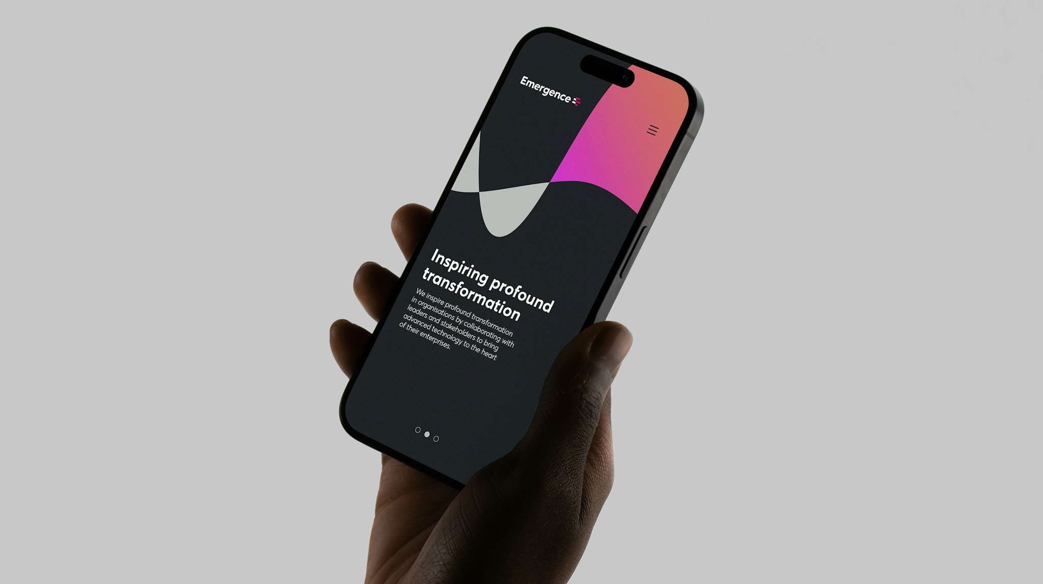 Hand holding smartphone displaying Emergence website with modern design and text reading ‘Inspiring profound transformation’