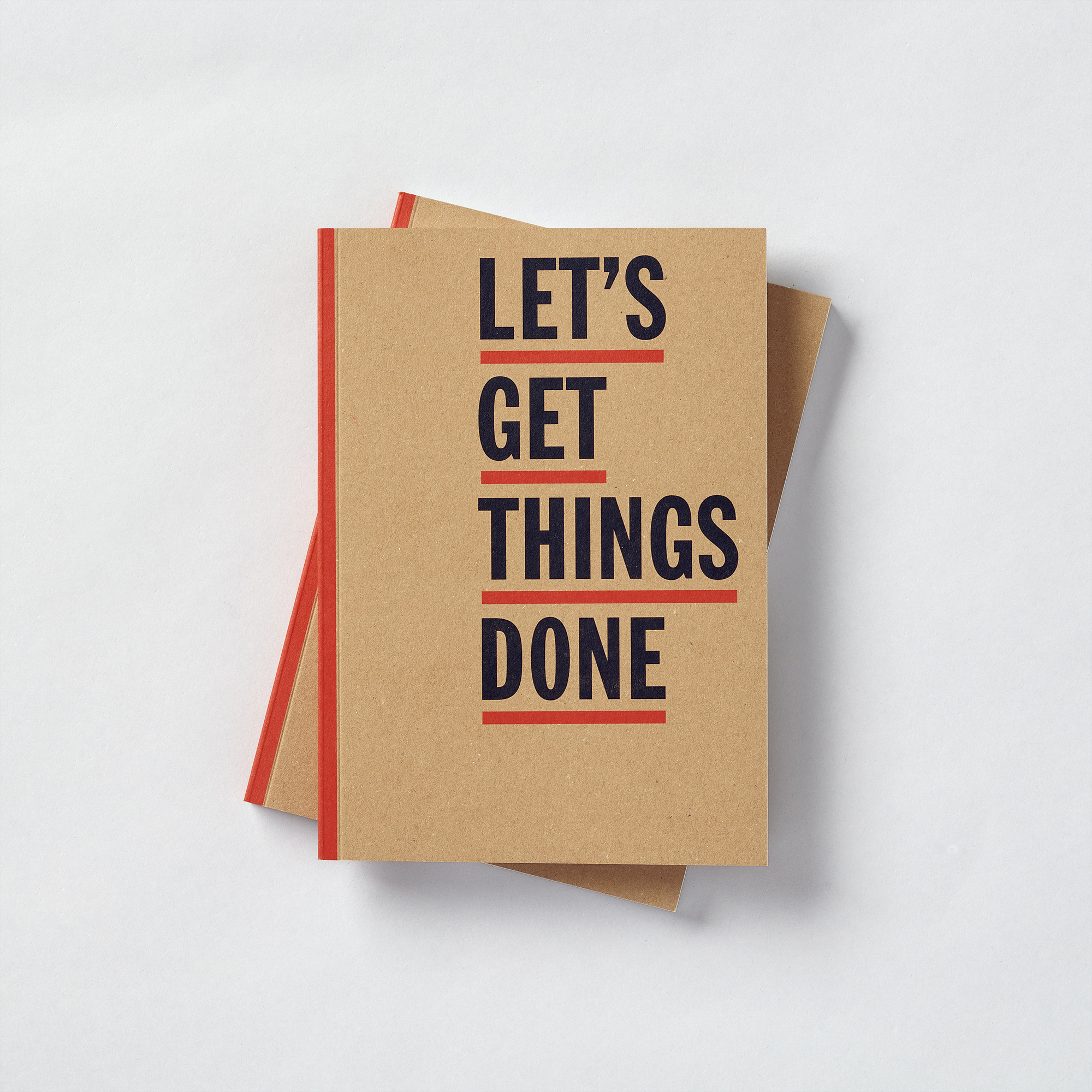 Stack of Kraft notebooks with bold black 'Let’s get things done' typography and red cover details on light grey surface