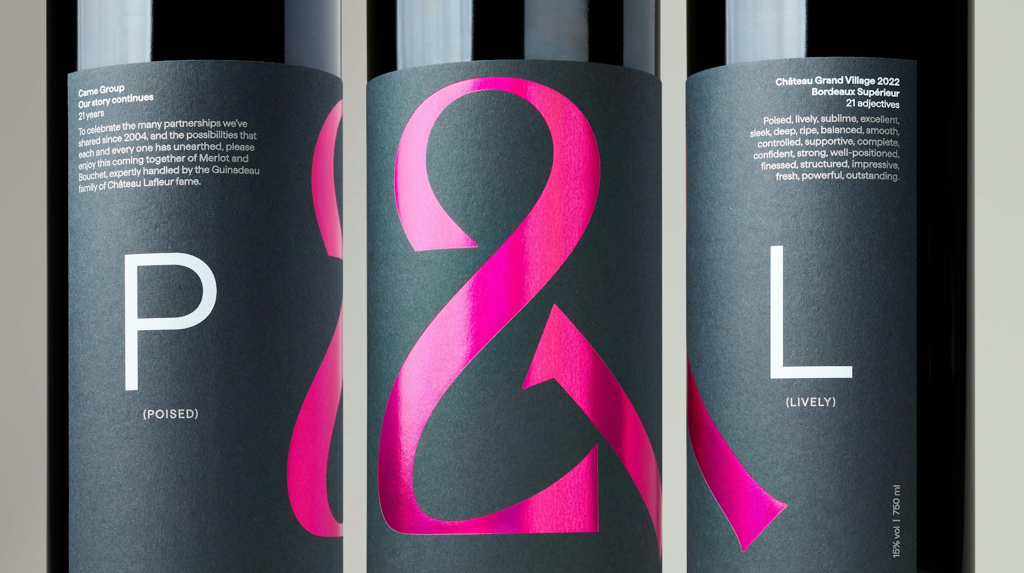Close-up of three red wine bottles with P&L label featuring hot pink holographic ampersand and white text on dark grey