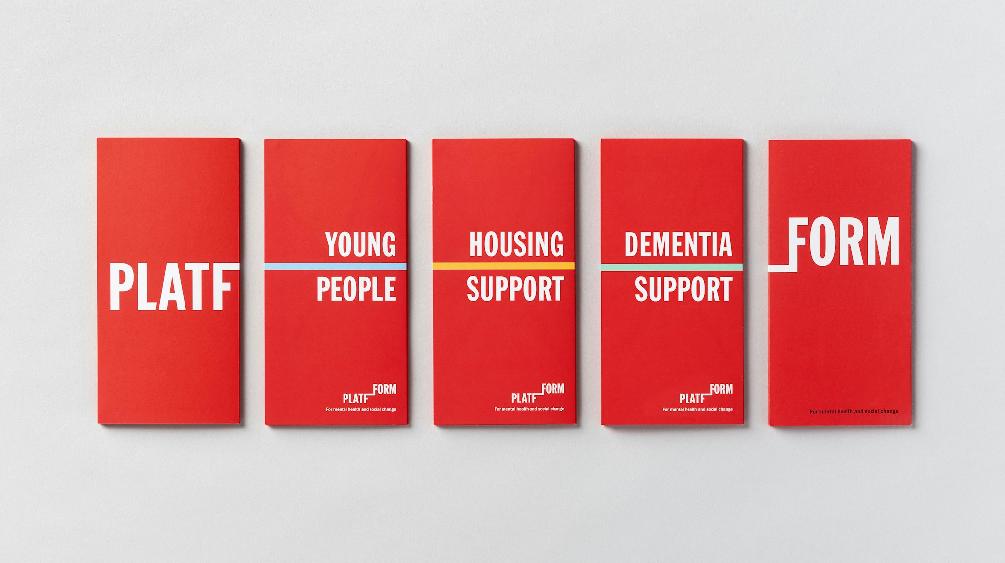Line-up of red Platfform brochures on the different communities they support on light grey background