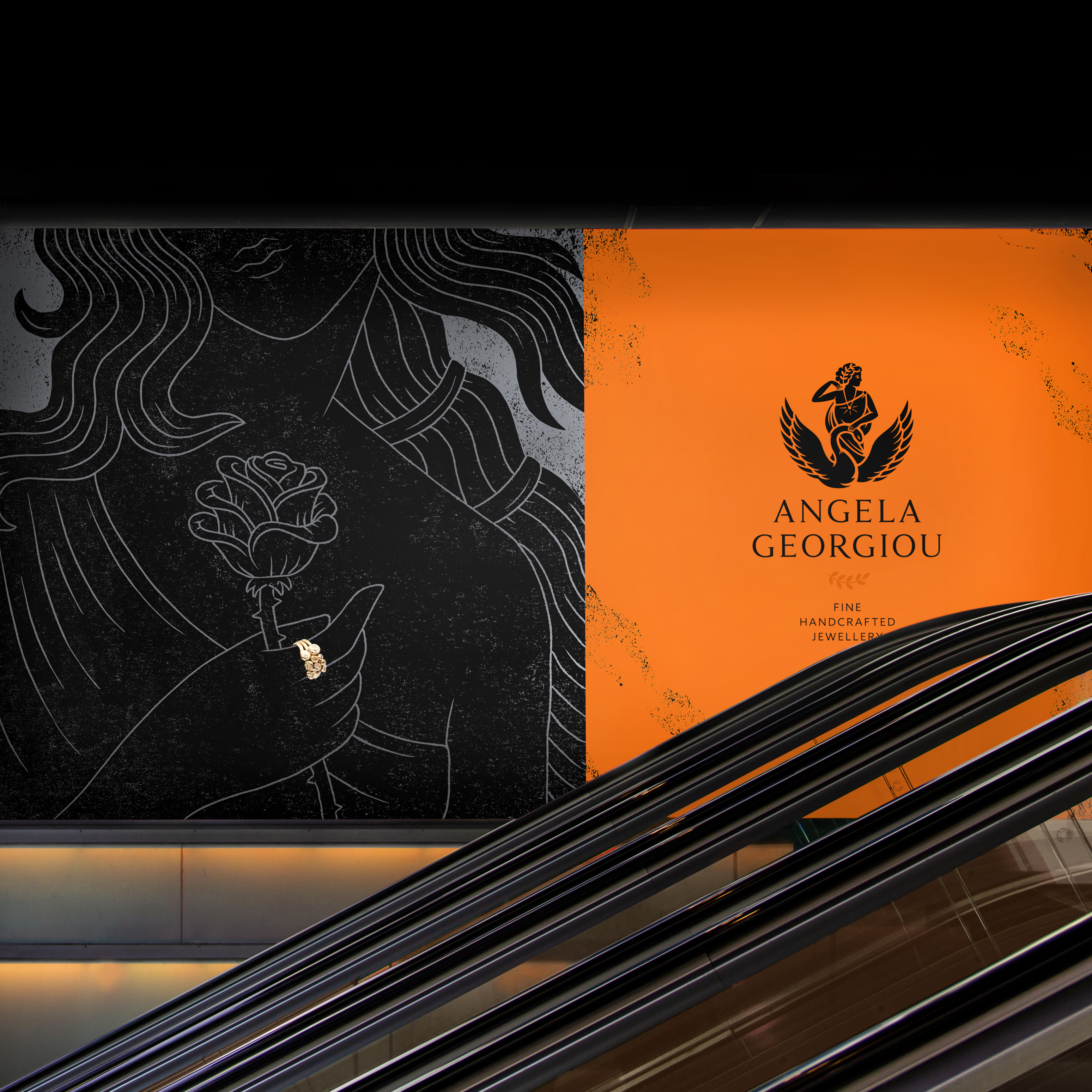 Luxury billboard in shopping mall showing black & grey Greek goddess illustration with gold ring, Angela Georgiou logo and strapline on bronze