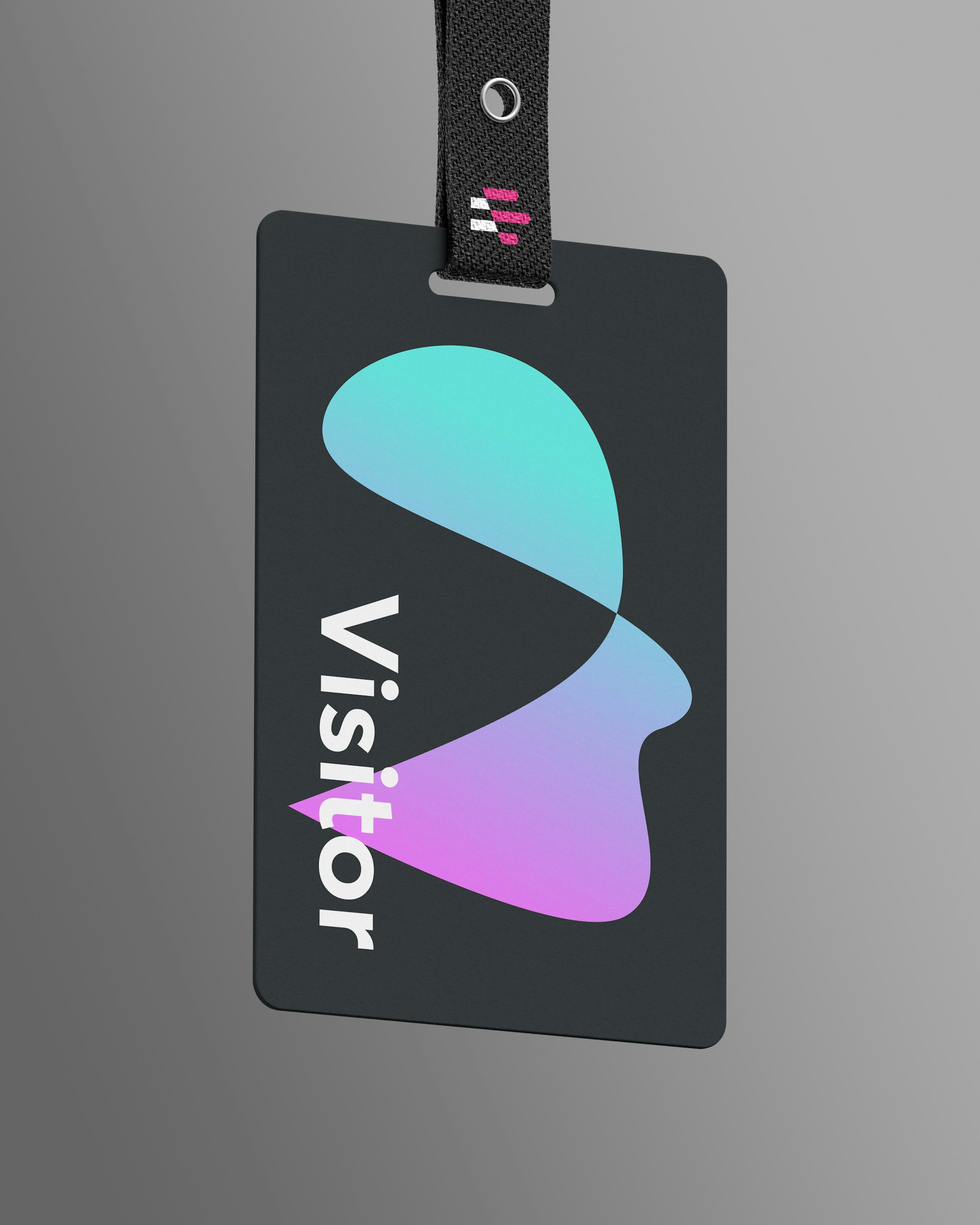 Emergence visitor badge with abstract shape forming a face, attached to a branded lanyard.