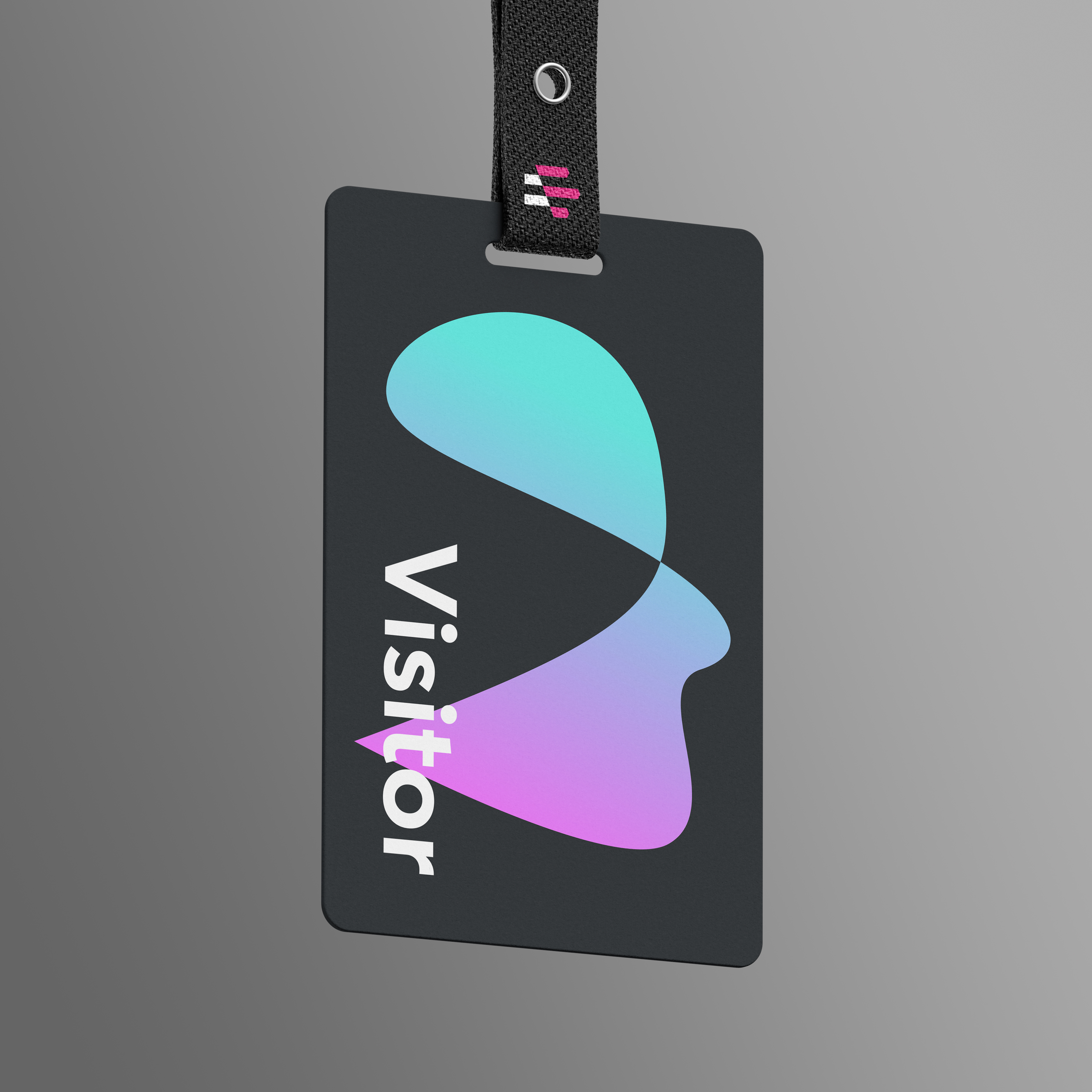 Dark grey badge with fluid shape resembling human face in green-pink gradient, "Visitor" in white, Emergence logo on lanyard, against grey backdrop