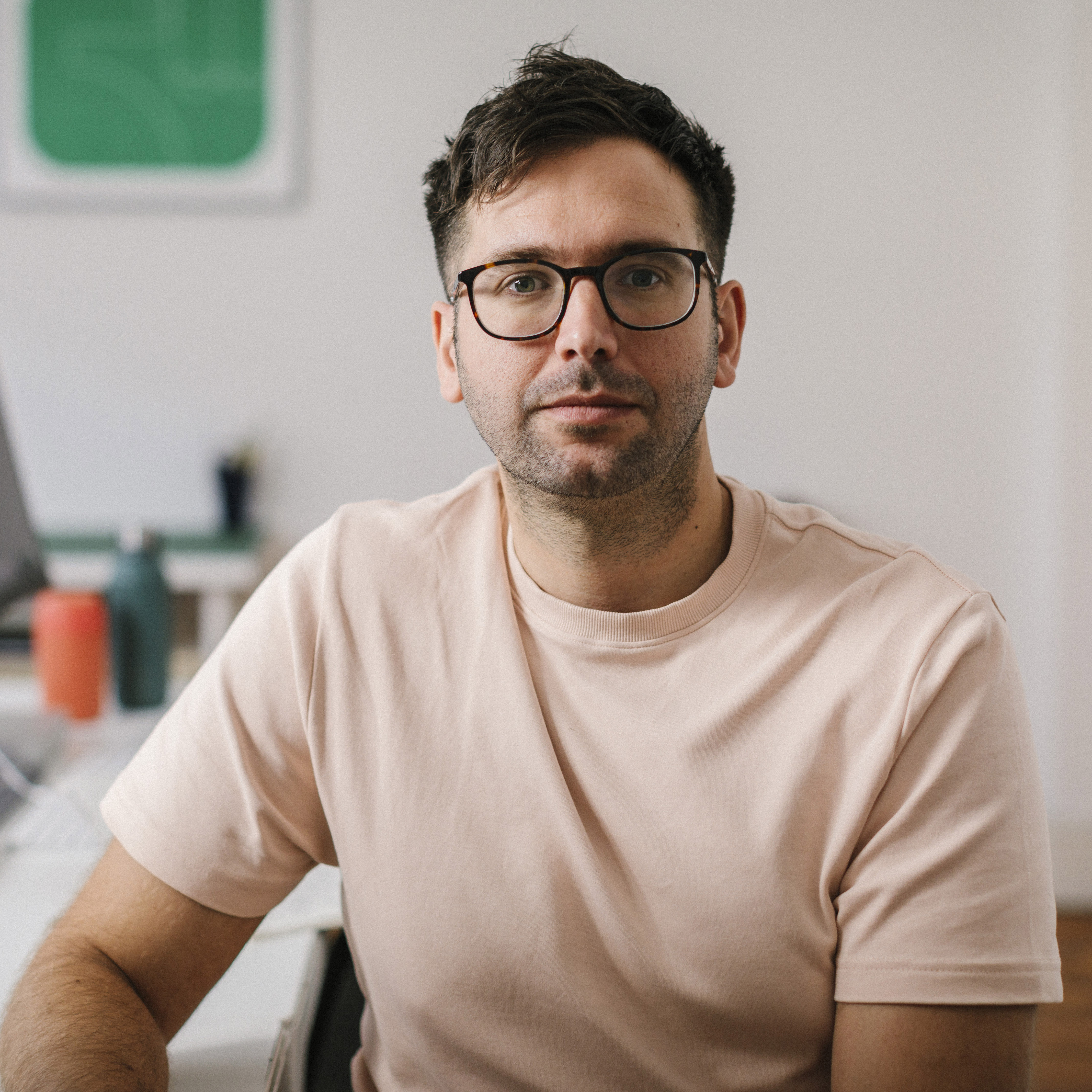 Confident man with glasses sitting in modern design studio