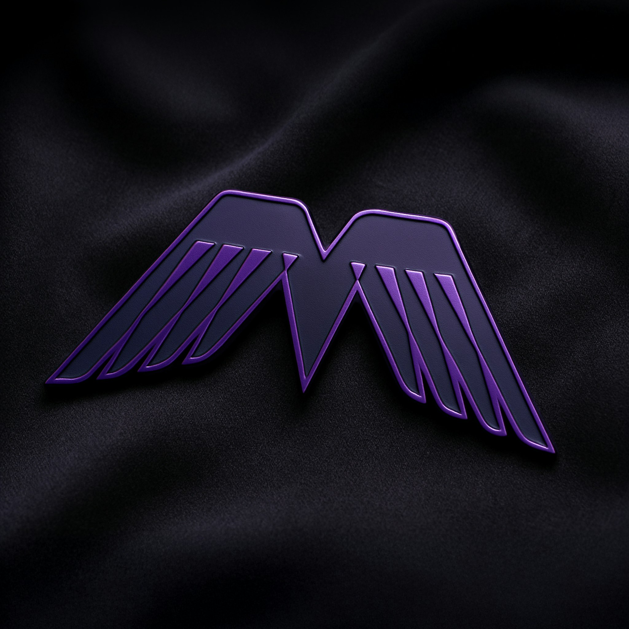 Metal pin badge of Prompt Mavericks wing symbol in bright and dark purple on soft dark grey fabric