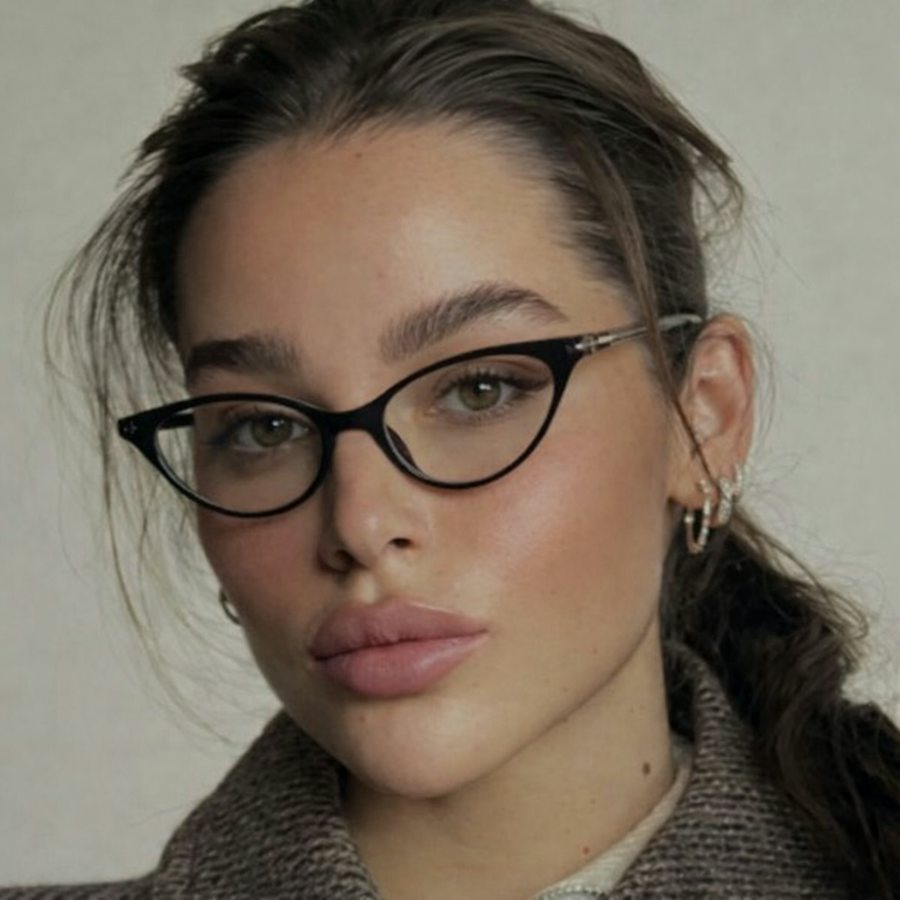 Woman wearing a cat eye shaped black plastic frame