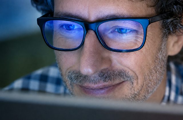 Man wearing blue light blocking glasses