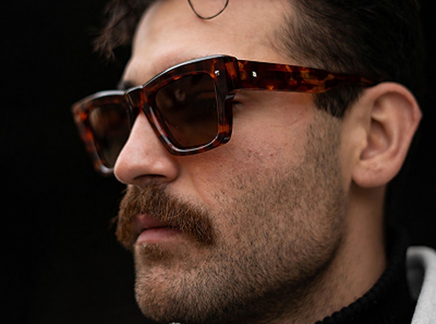 Man wearing a bold havana plastic wayfarer style sunglasses frame