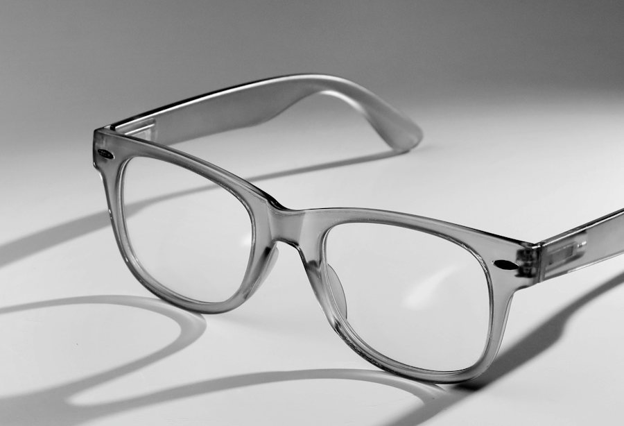 Transparent grey plastic glasses frame on a grey background