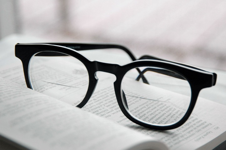 Black plastic frames fitted with bifocal lenses resting on an open book