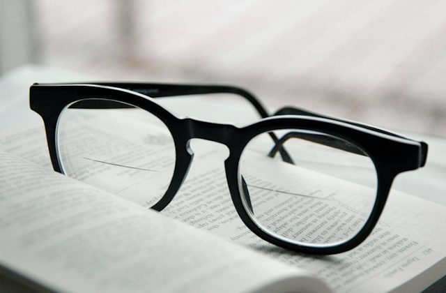 Black plastic frames fitted with bifocal lenses resting on an open book