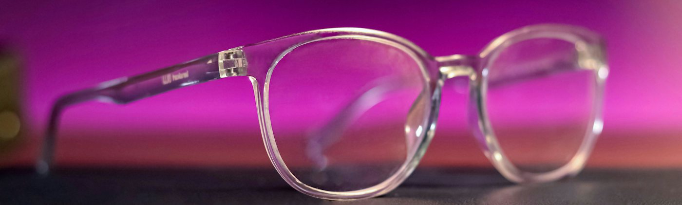 Clear plastic glasses frame on a pink background