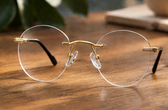 Rimless frame with round lenses resting on a wooden table