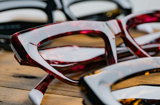 Row of different coloured cat eye shaped frames on a wooden table