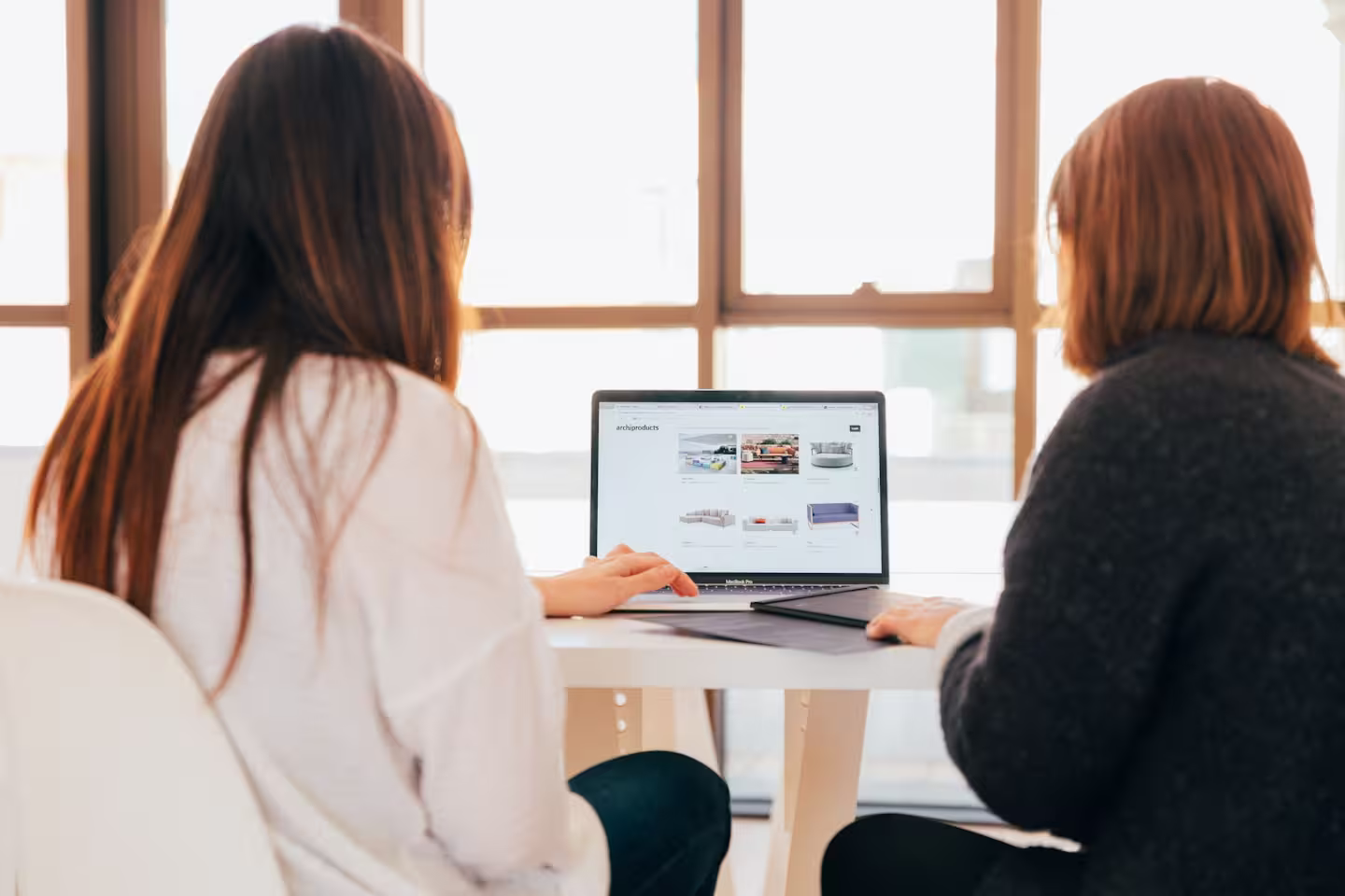 Team members reviewing product options on a laptop during an office meeting