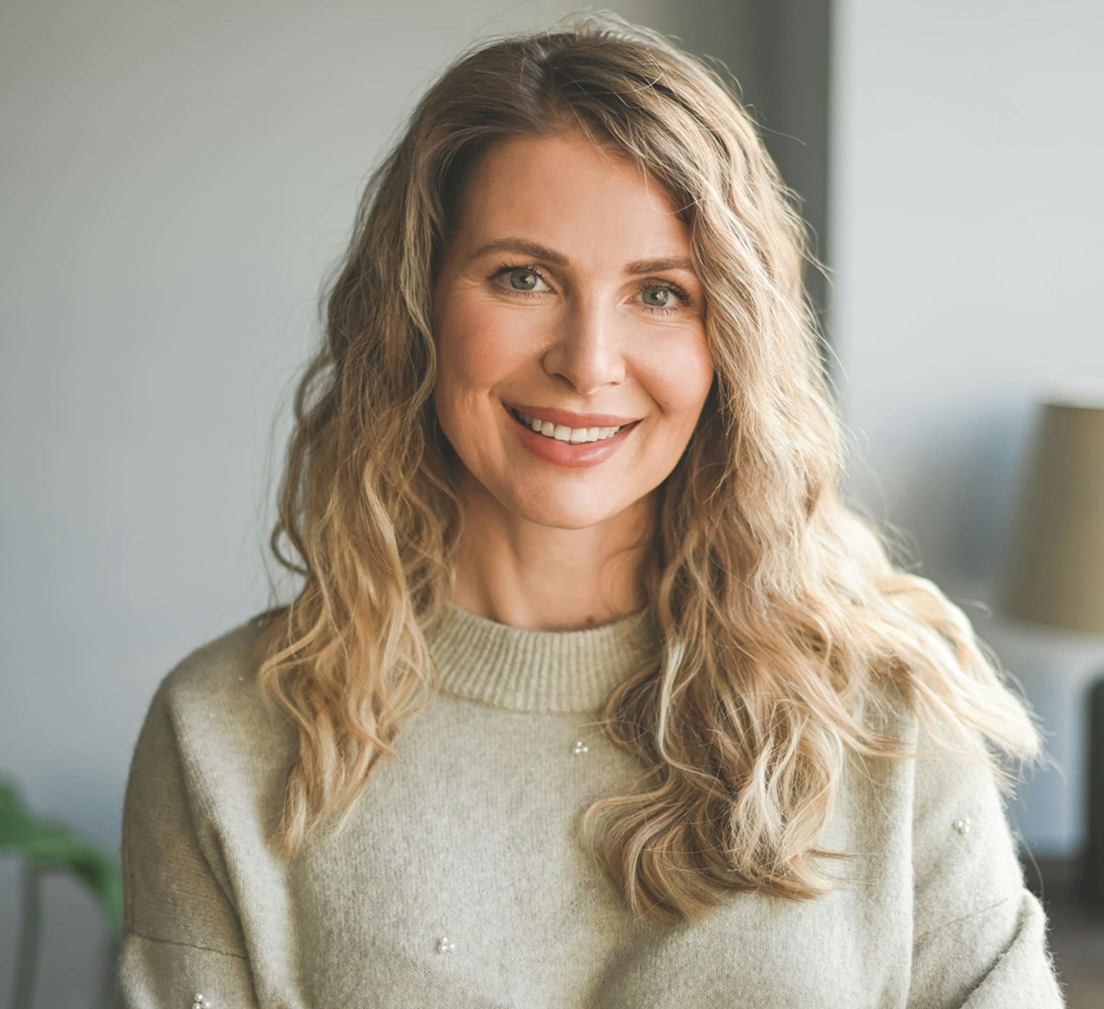 woman with wavy blonde hair smiling