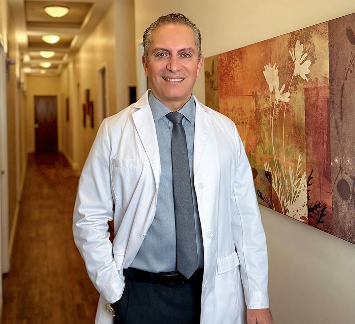 Dr. Cohen in hallway smiling with hand in his pocket