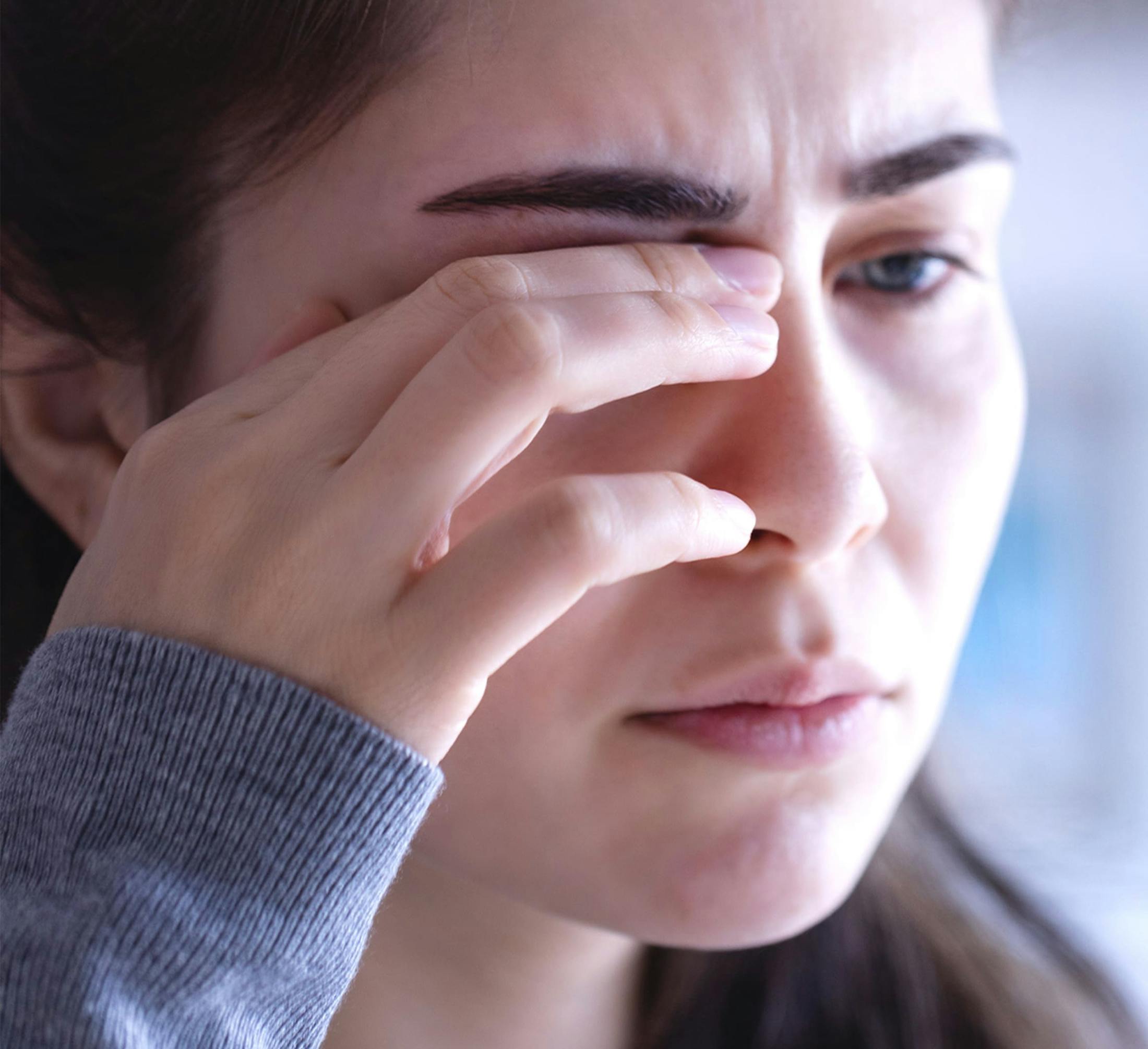 woman rubbing her eye