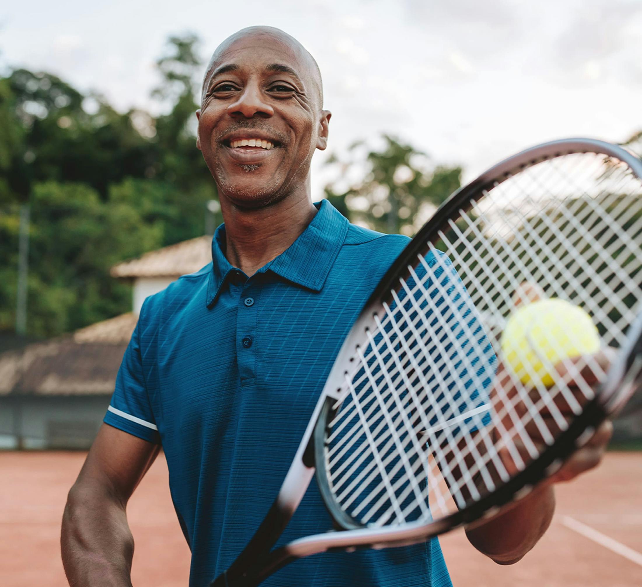 man holding tennis racket and ball