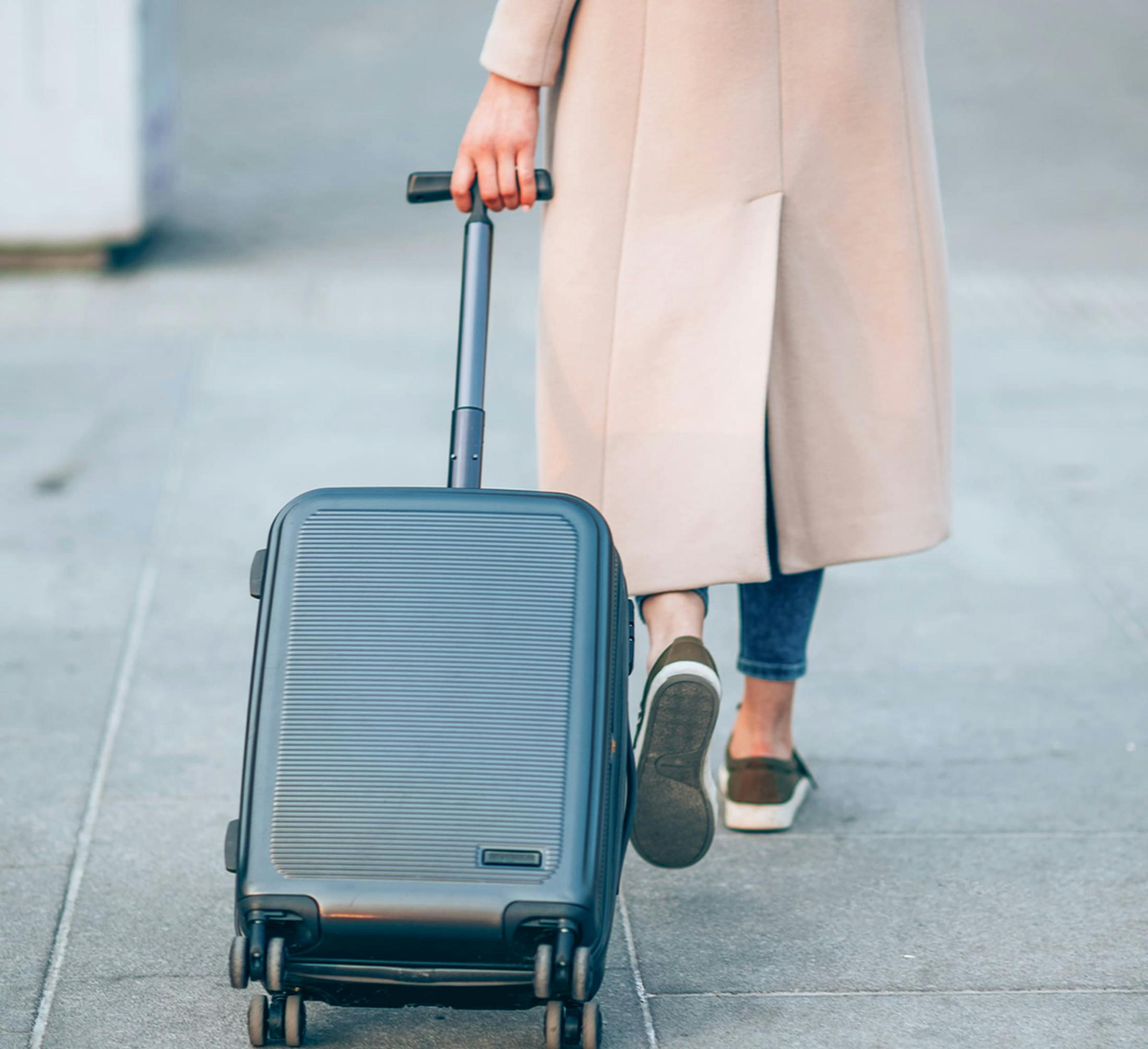 woman with a suitcase walking on the sidewalk