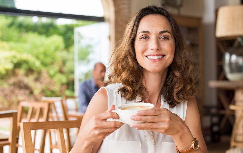 woman sitting down holding a cup of coffee