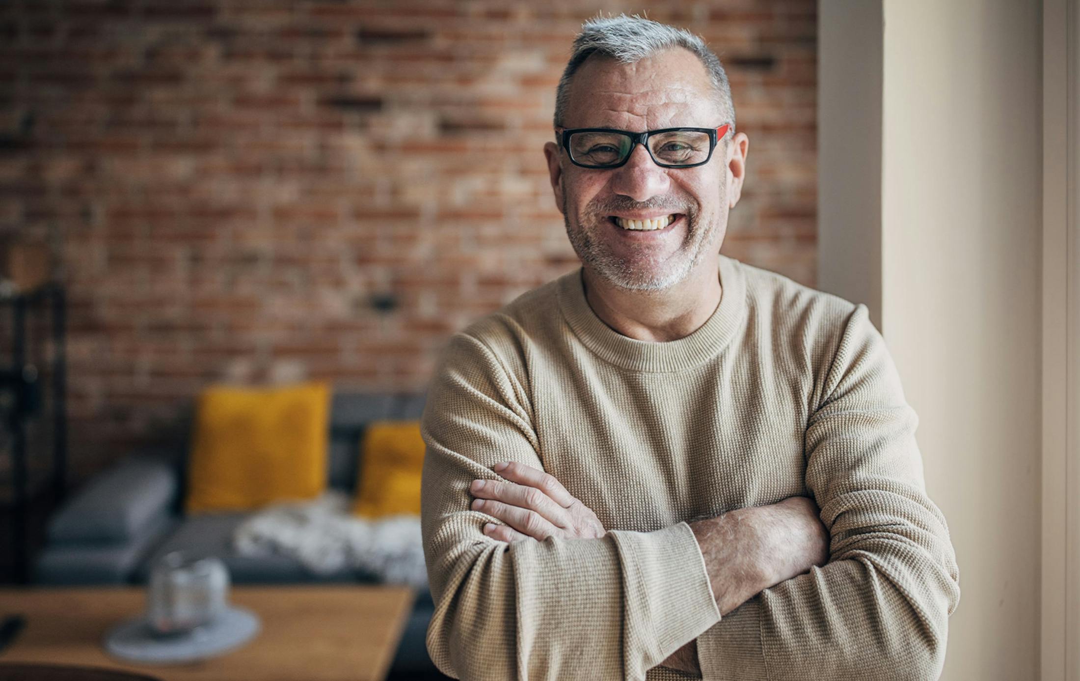 older man crossing his arms and smiling
