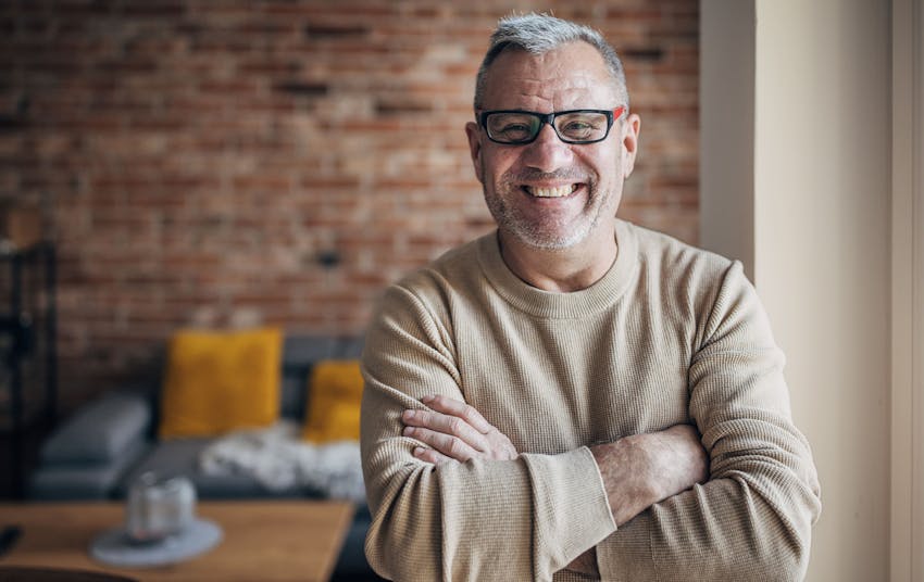 older man crossing his arms and smiling