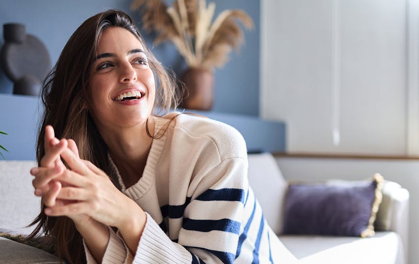 Woman laughing with hands clasped