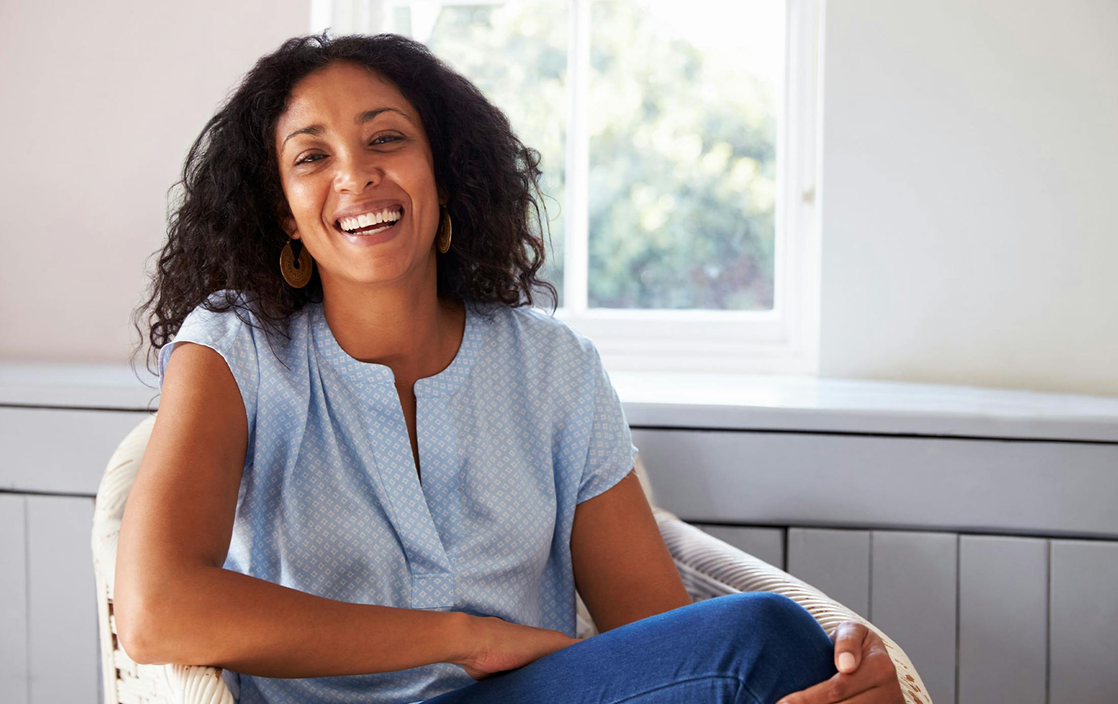 Woman laughing while sitting in a chair