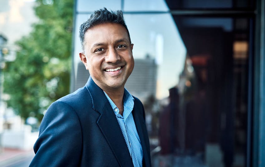 man smiling in suit outside building