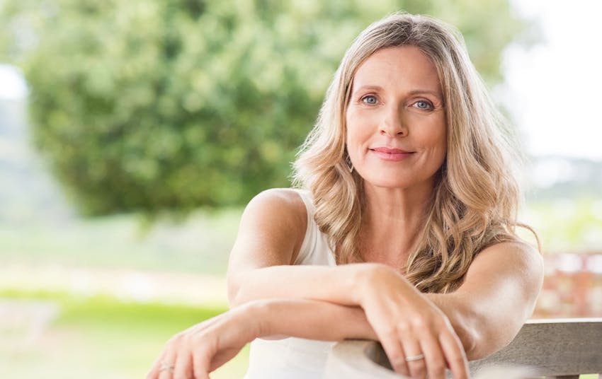 woman sitting on patio with arms on bench