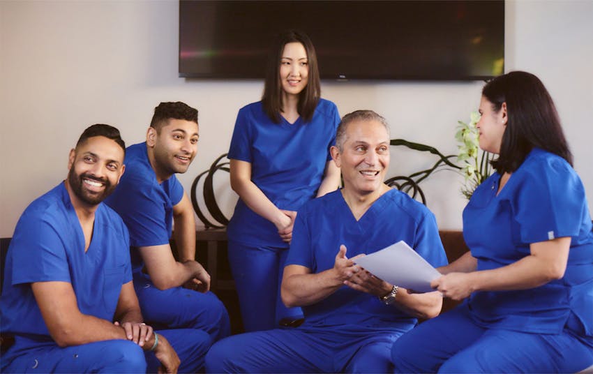 Dr. Cohen talking to 2 female staff members at the front desk