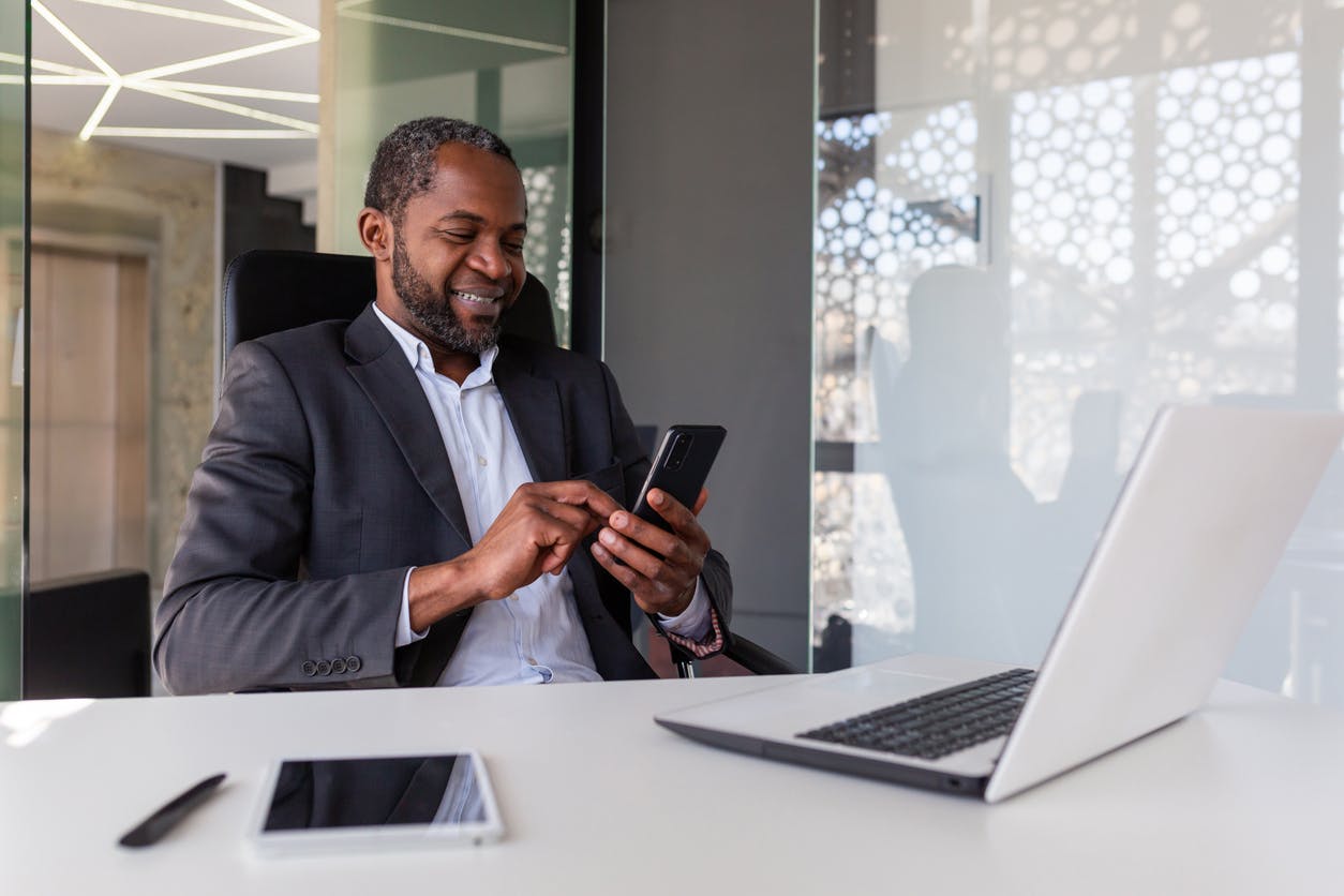 man texting at his desk