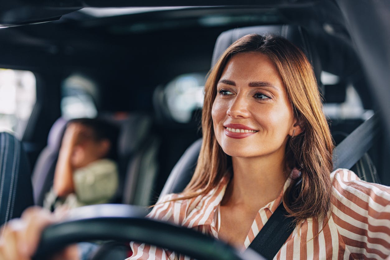 woman driving with her young son in the backseat