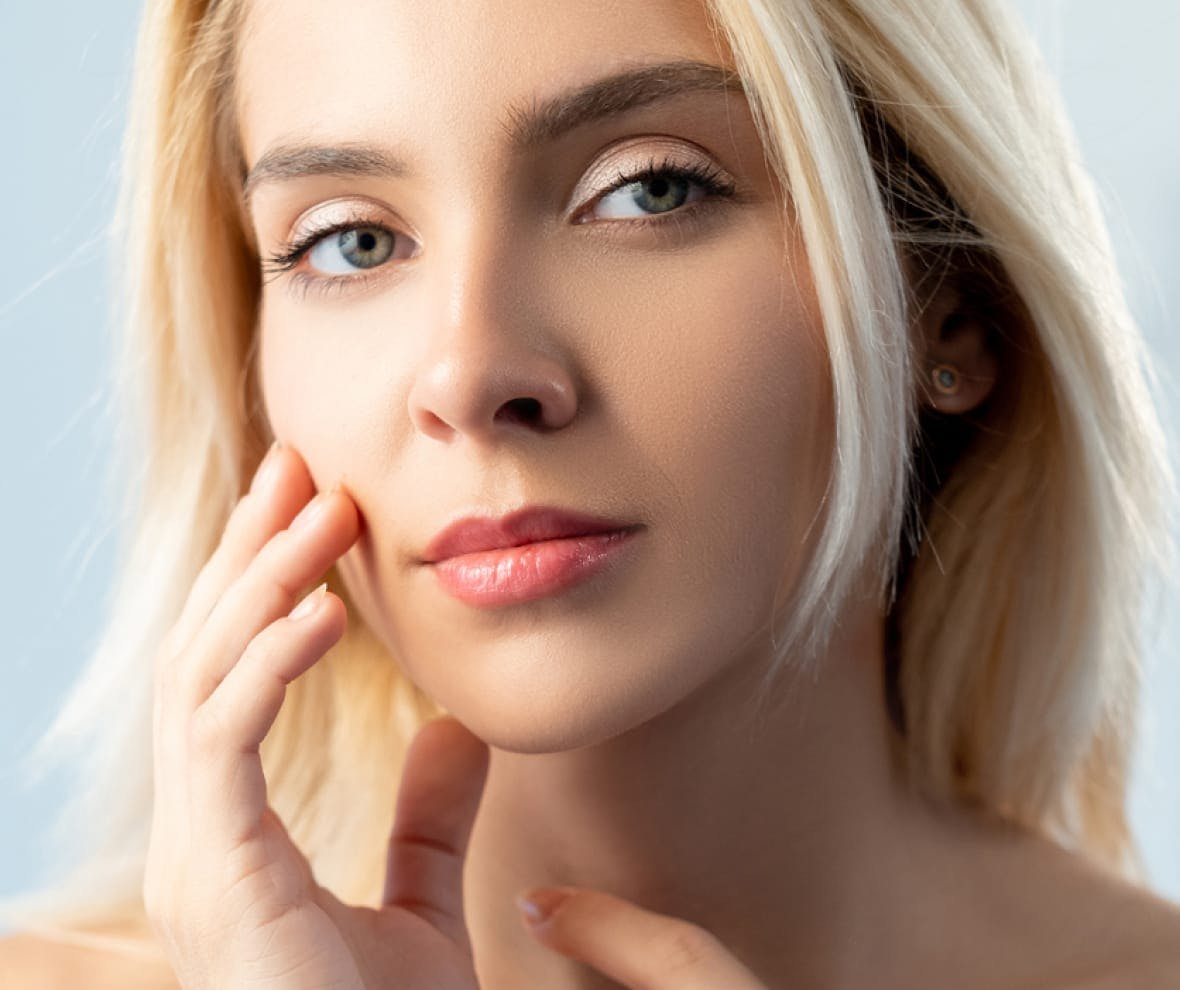 blonde woman touching her cheek
