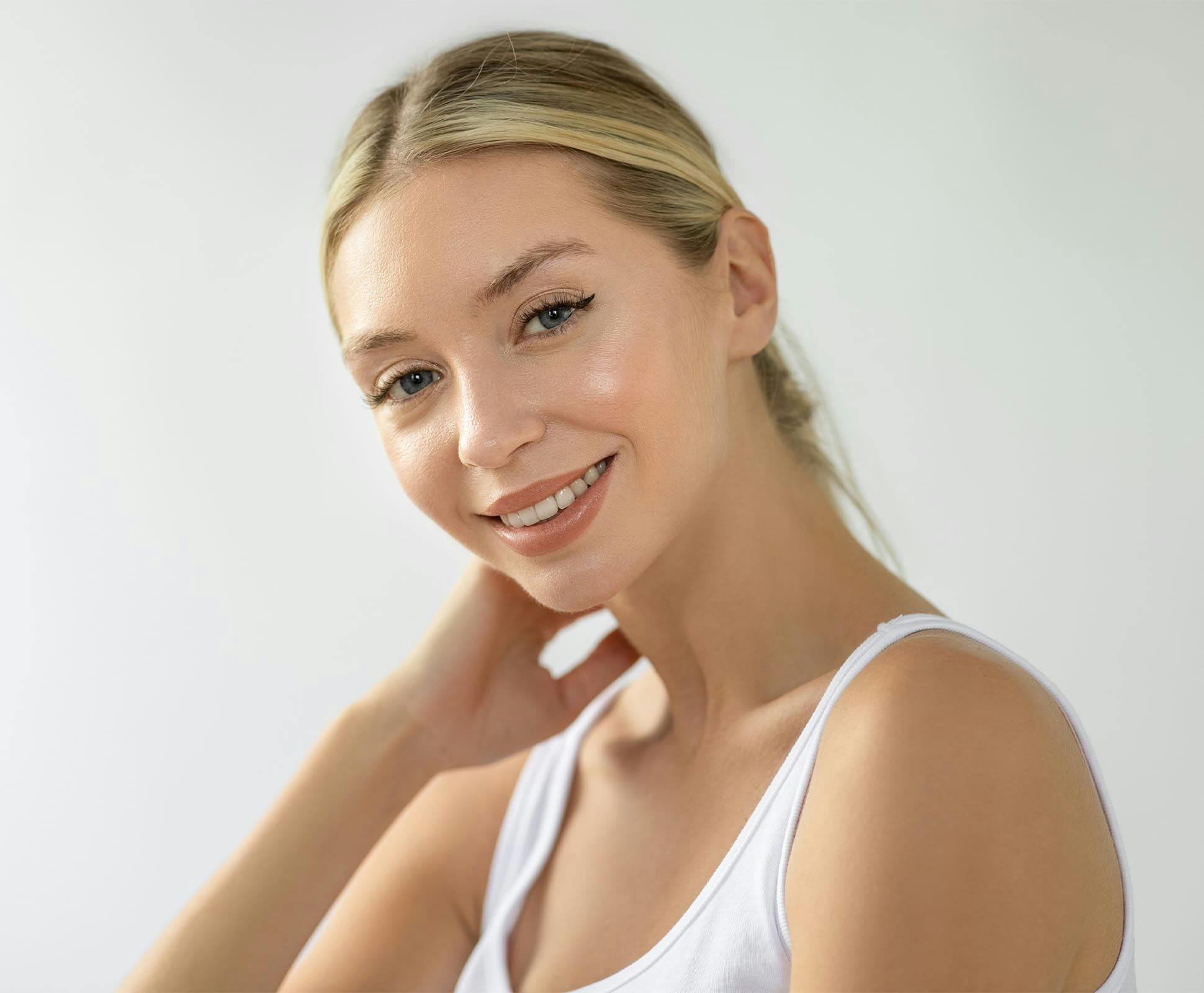 woman with her hair tied back and her hand on her neck