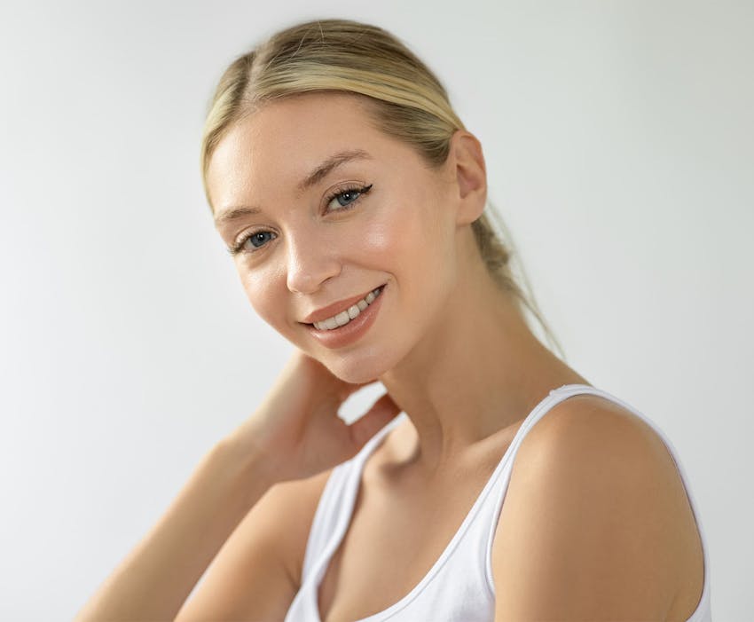 woman with her hair tied back and her hand on her neck