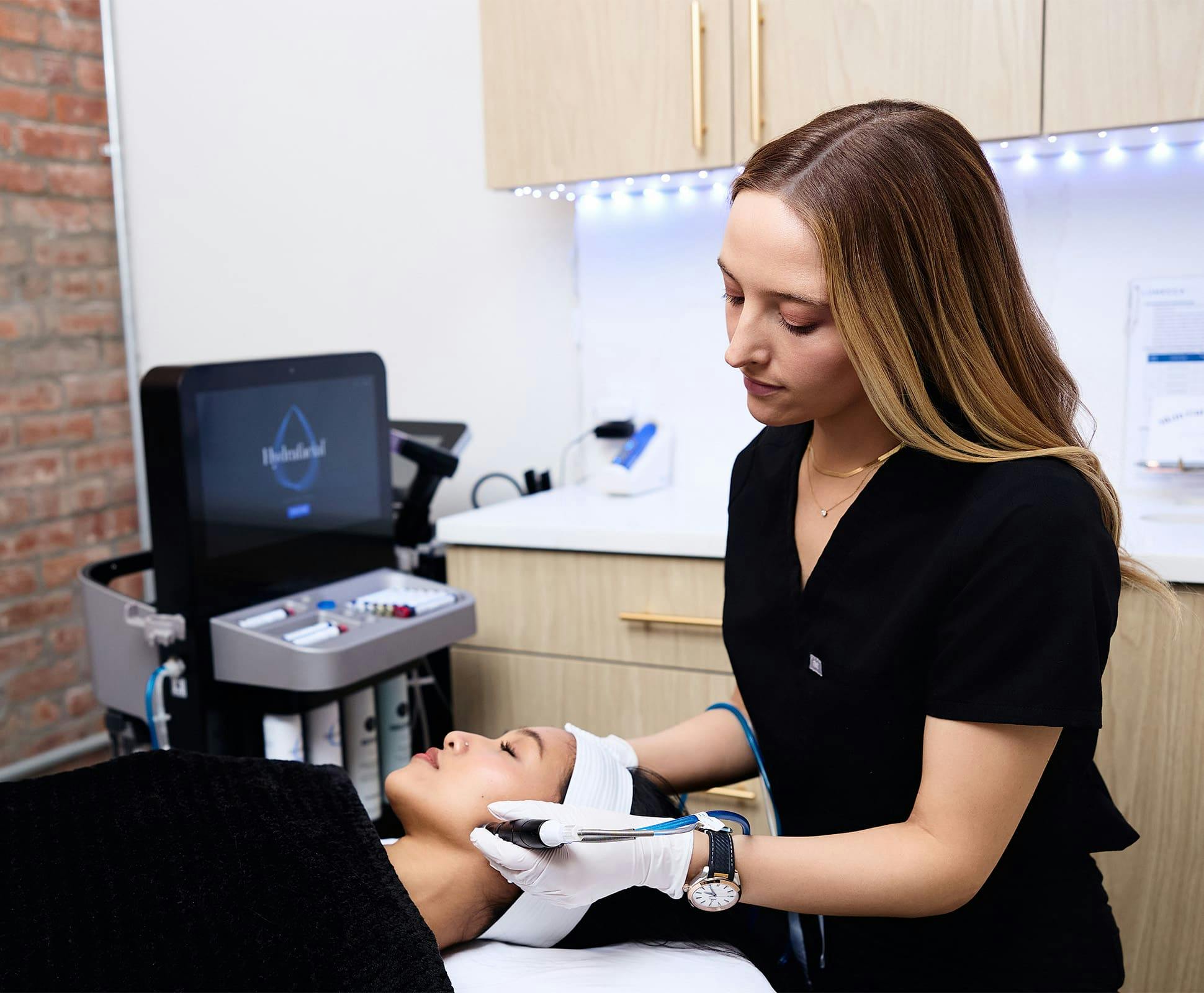 Camille Mckee doing hydra facial procedure on patient's cheek