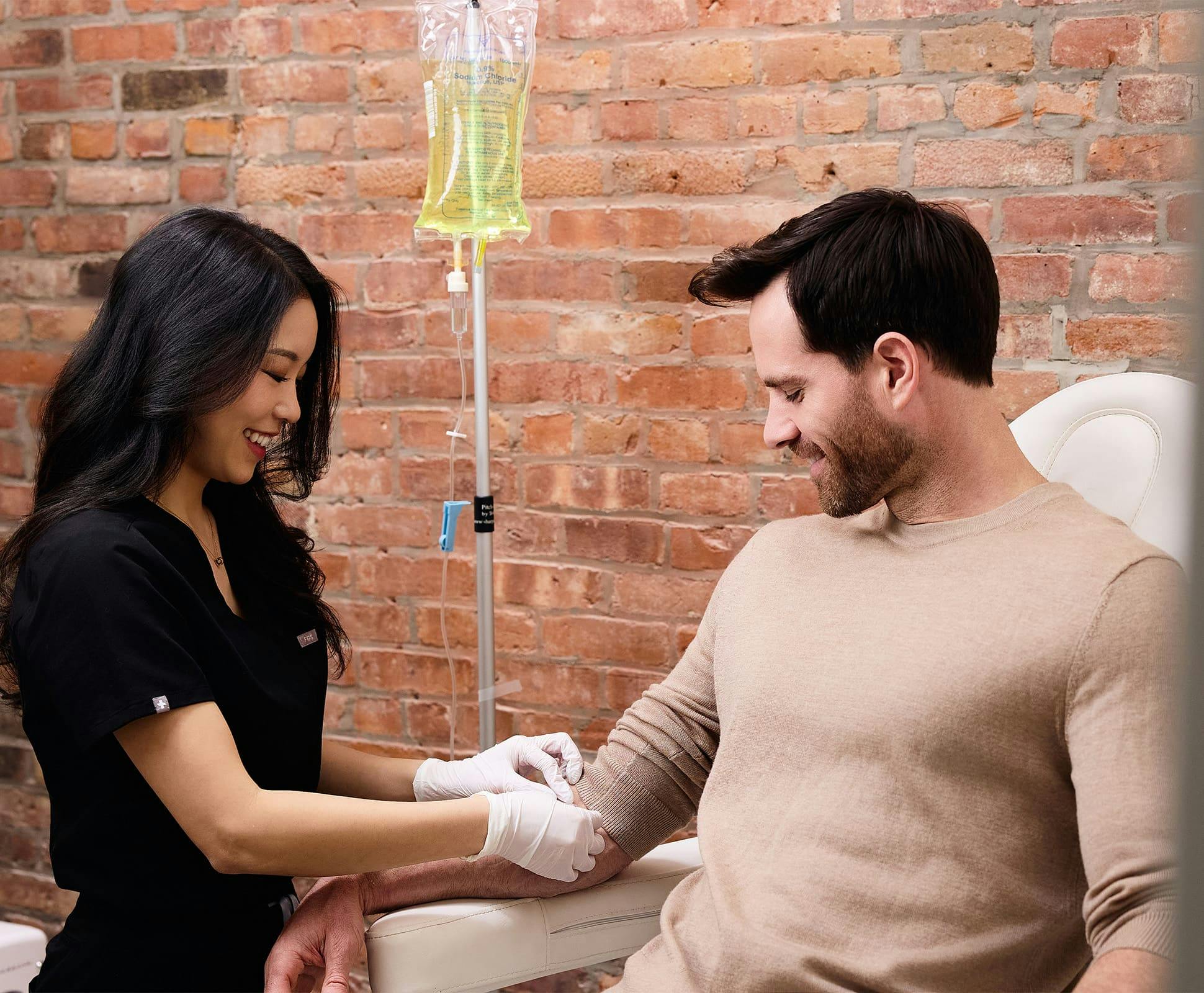 Chelsea Kim doing IV drip therapy on male patient