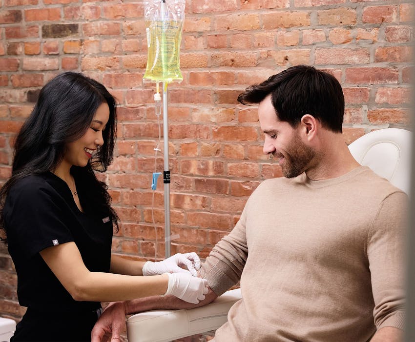 Chelsea Kim doing IV drip therapy on male patient