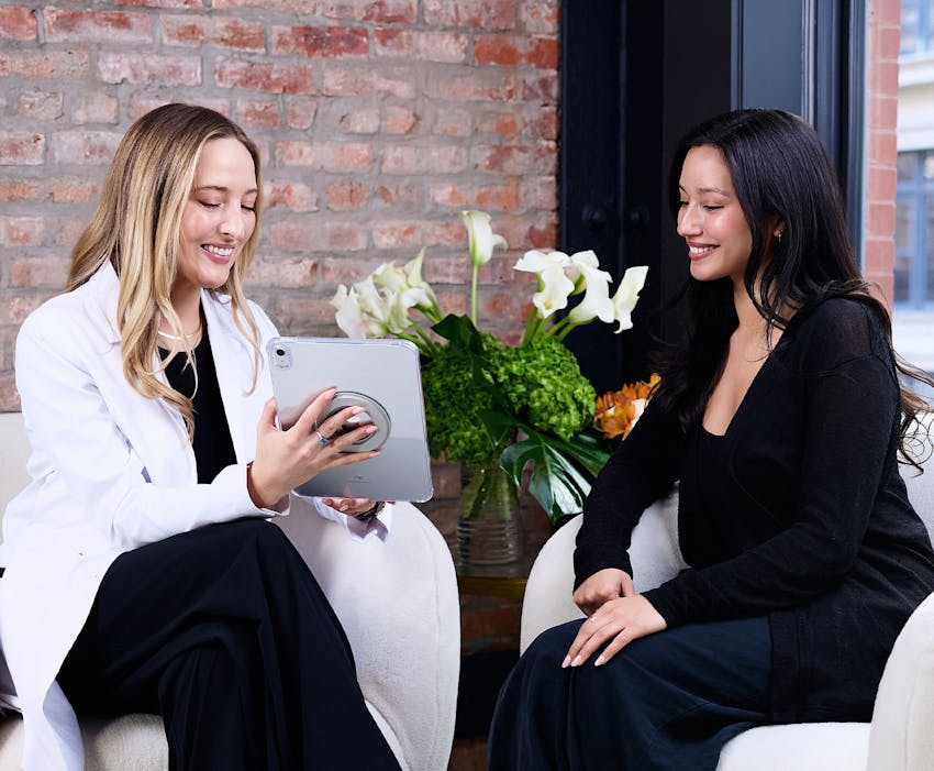 Camile Mckee showing ipad to patient while sitting down